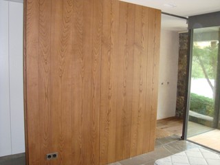 PANELADO EN MADERA NATURAL CON PUERTA PIVOTANTE